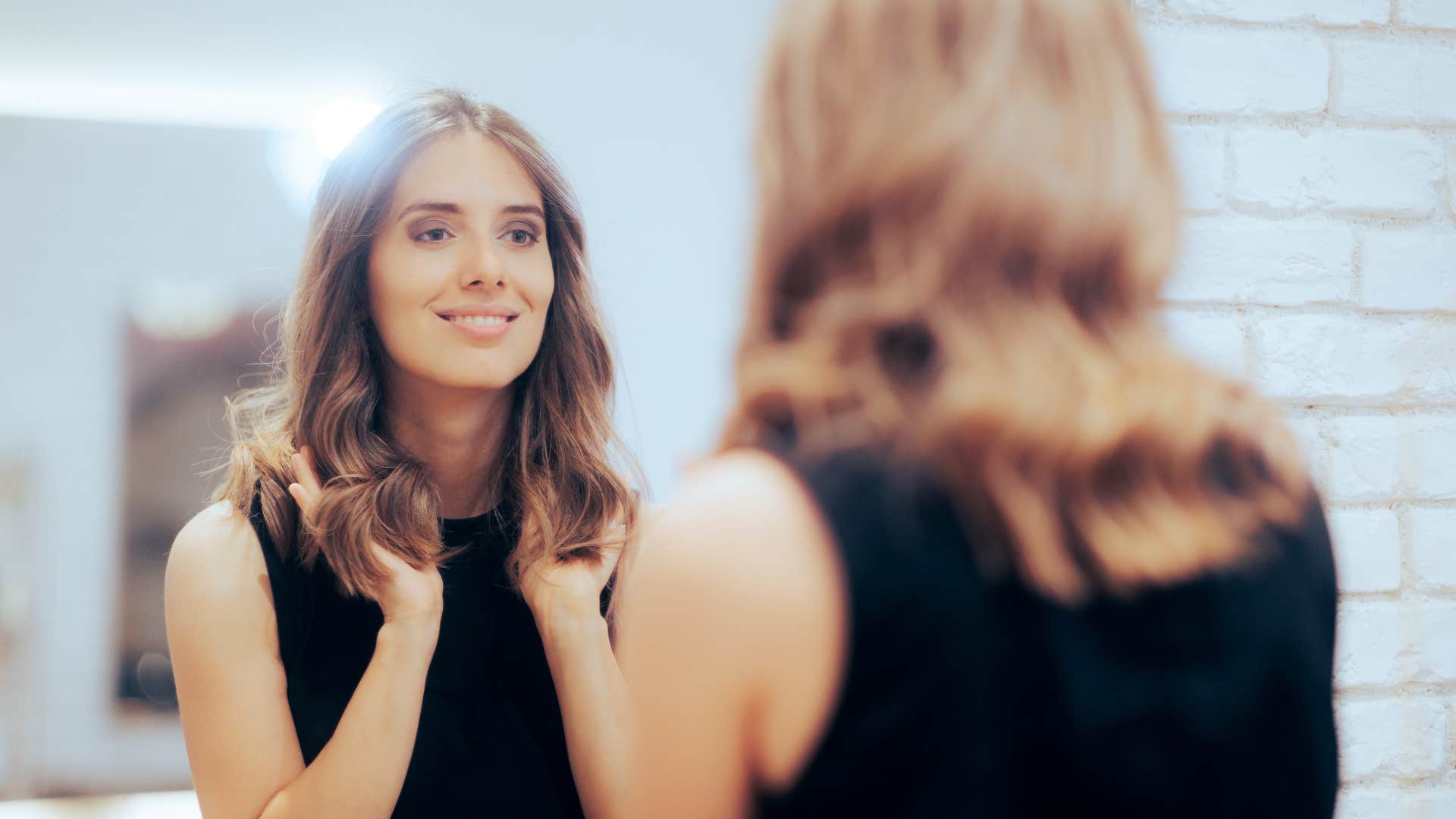 confident happy woman smiling in the mirror