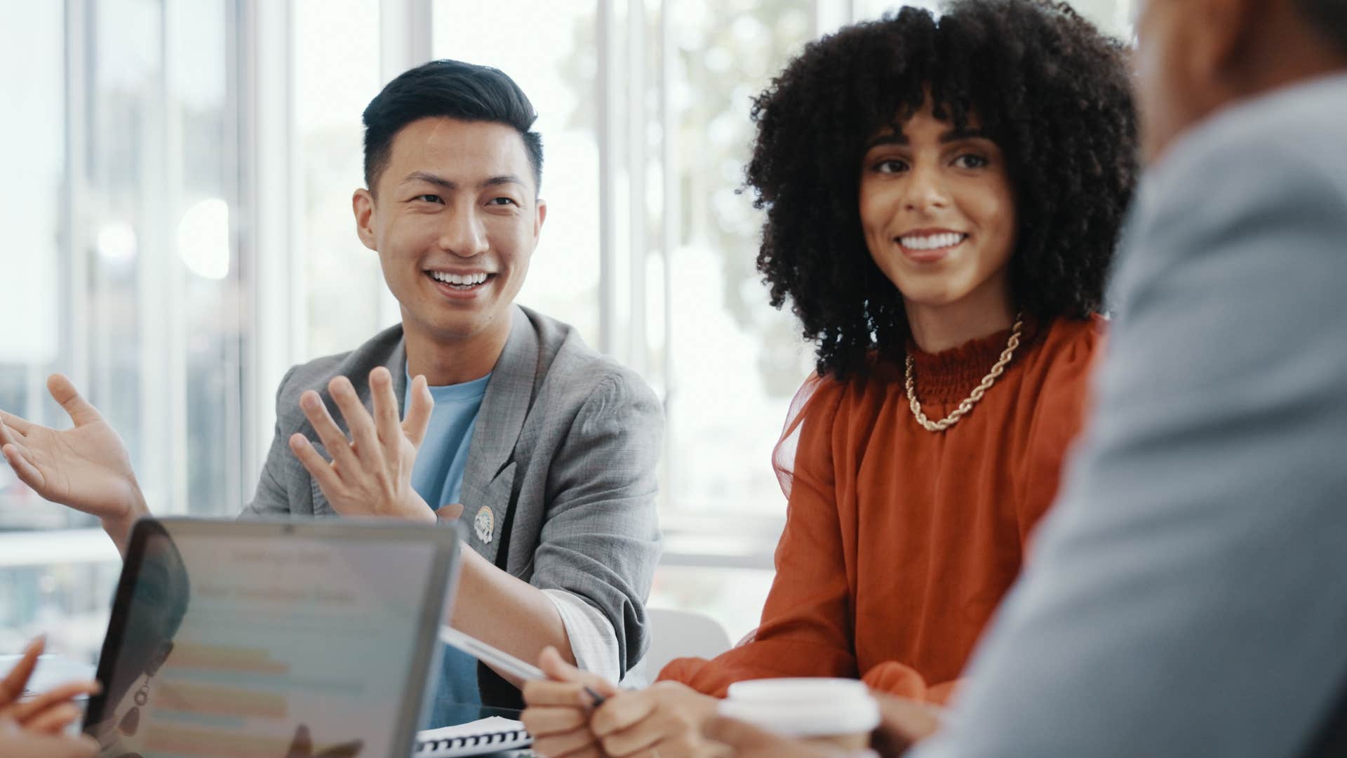 adults smiling and talking working on group project