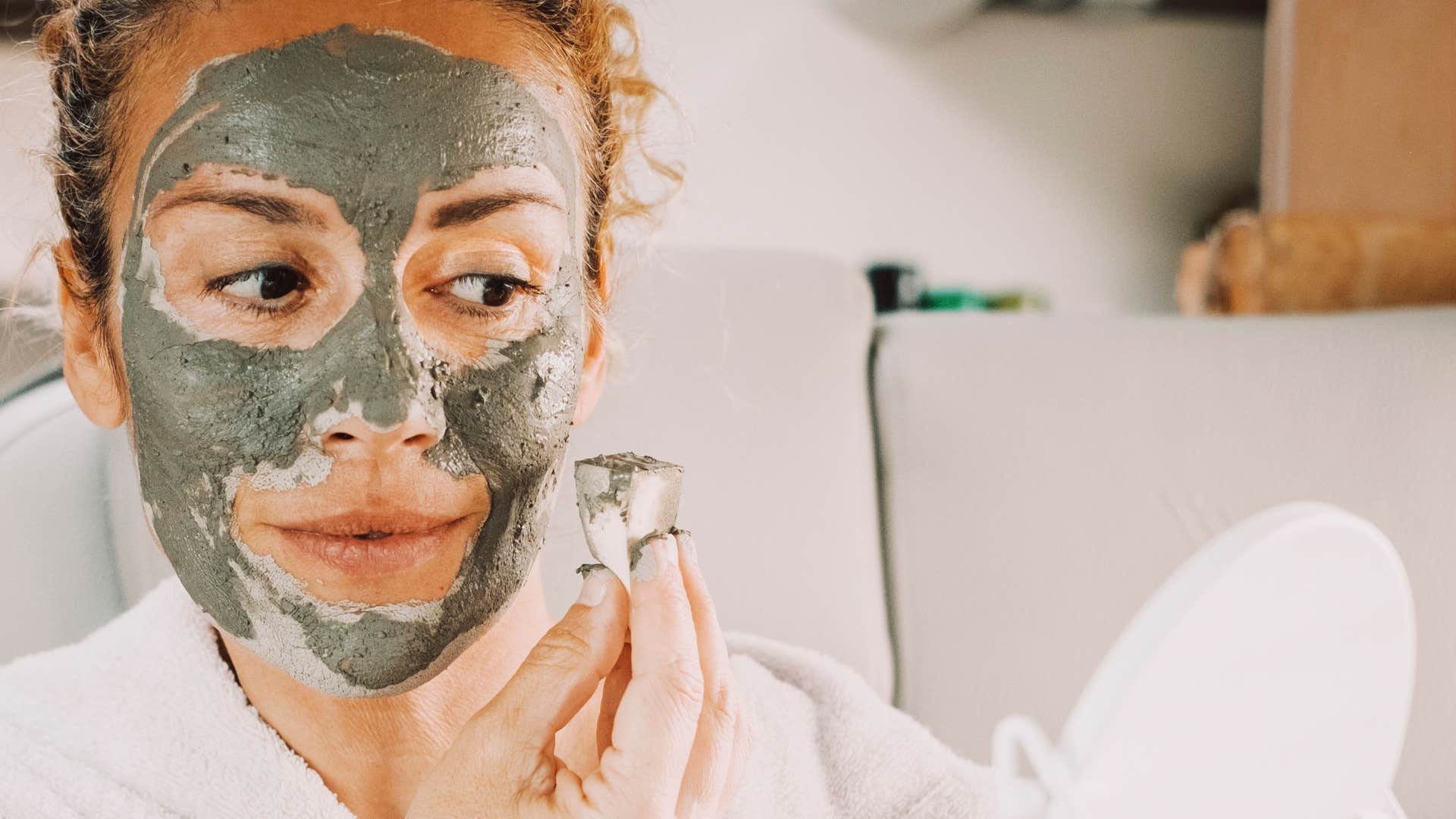 Woman smiling and doing self-care at home.
