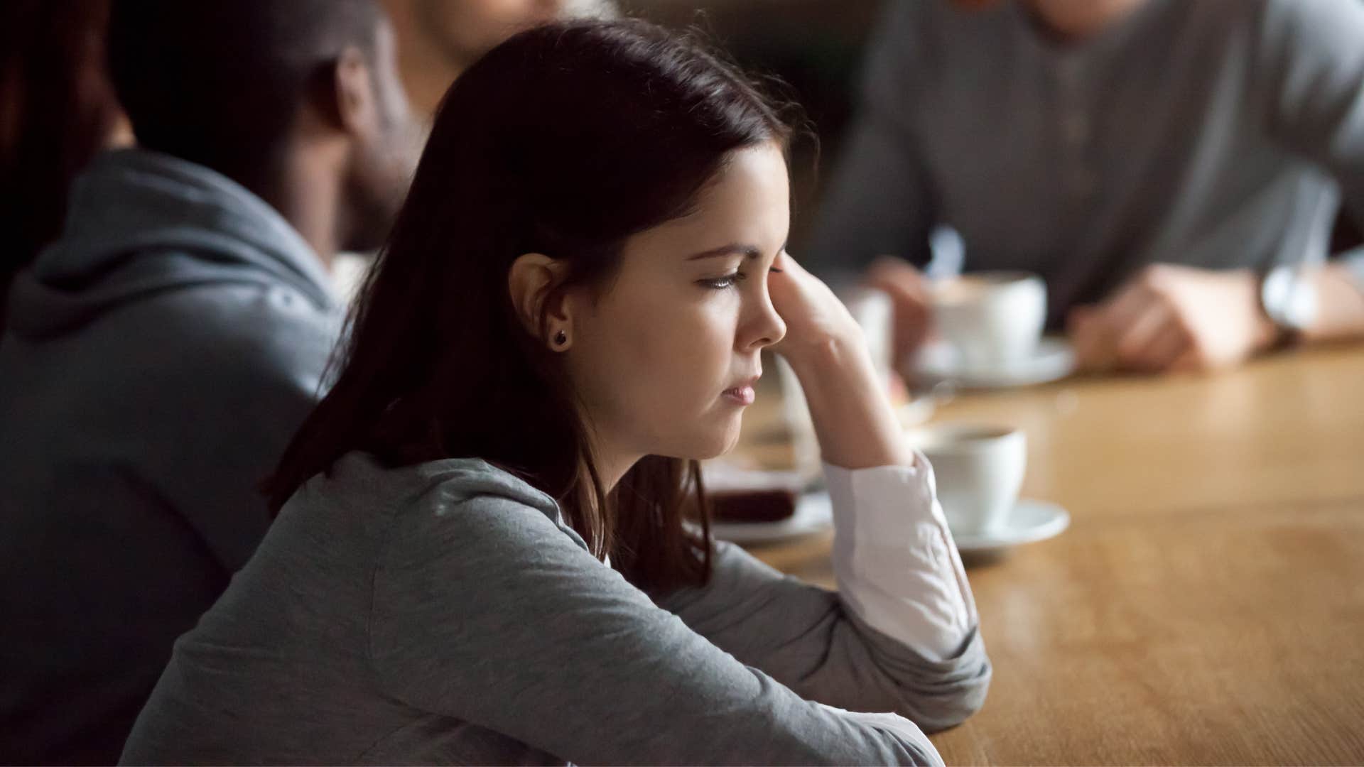 unhappy woman who's never excited looking away from her friends