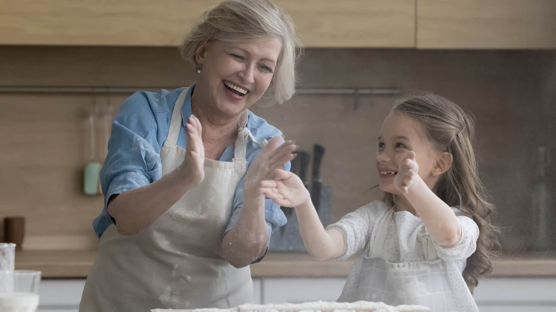 older woman who's done chasing perfection laughing in the kitchen with a young girl