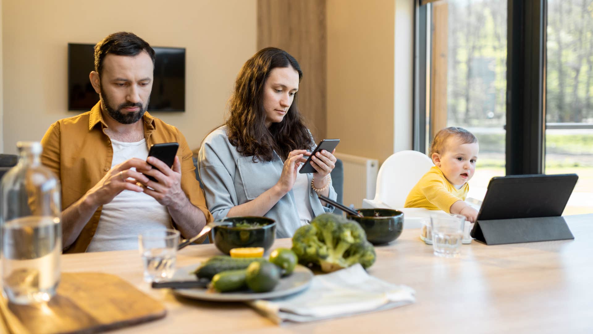 parents scrolling their phones during family dinner