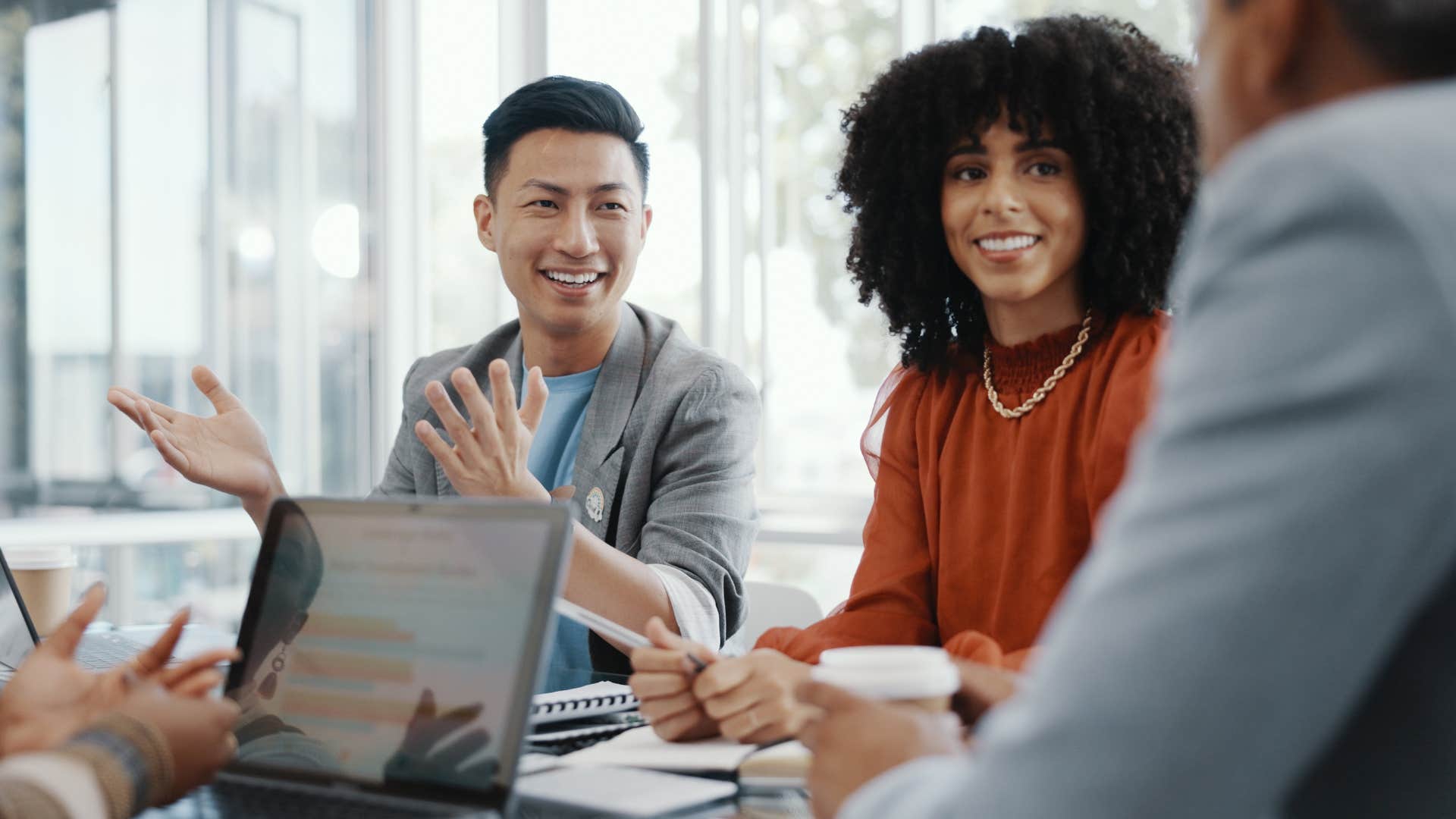 man doing a gathering with his coworker as he smiles and explains something