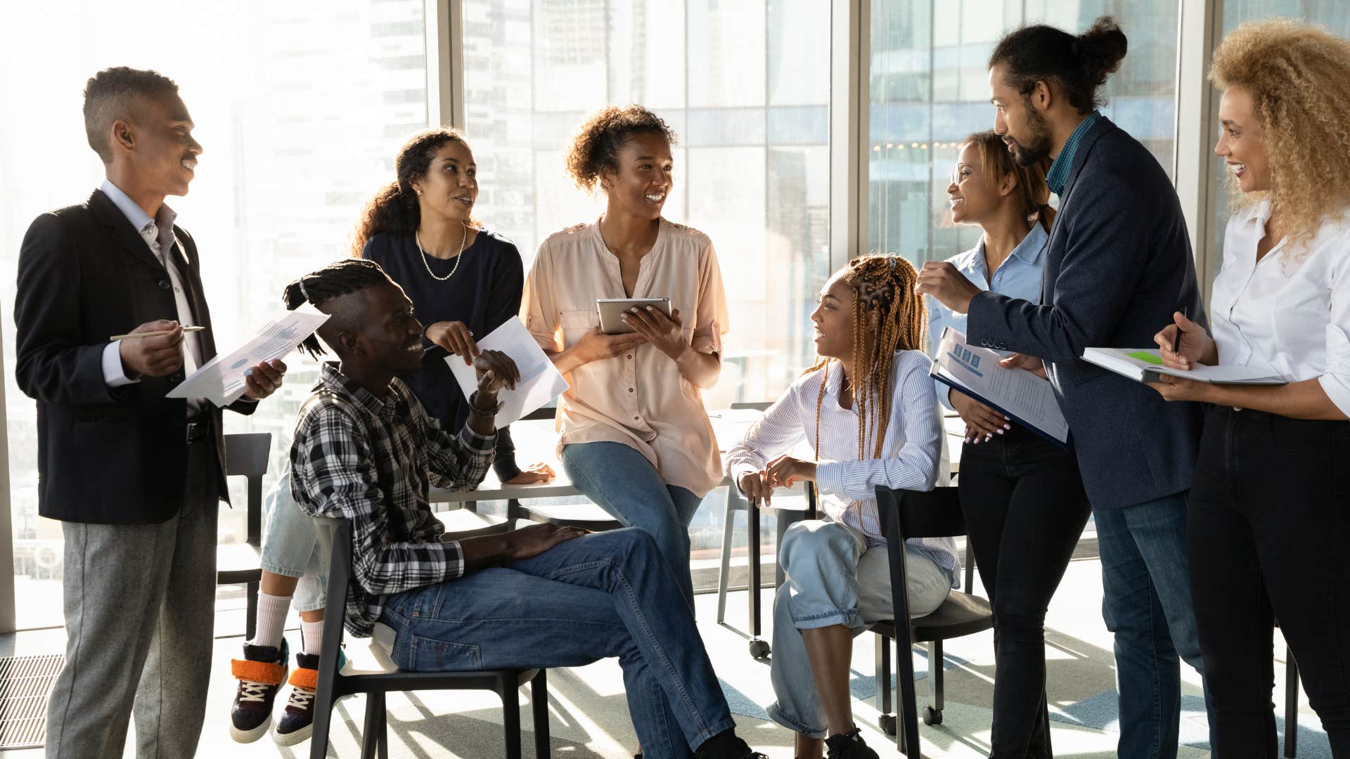group of work colleagues speaking with each other in office