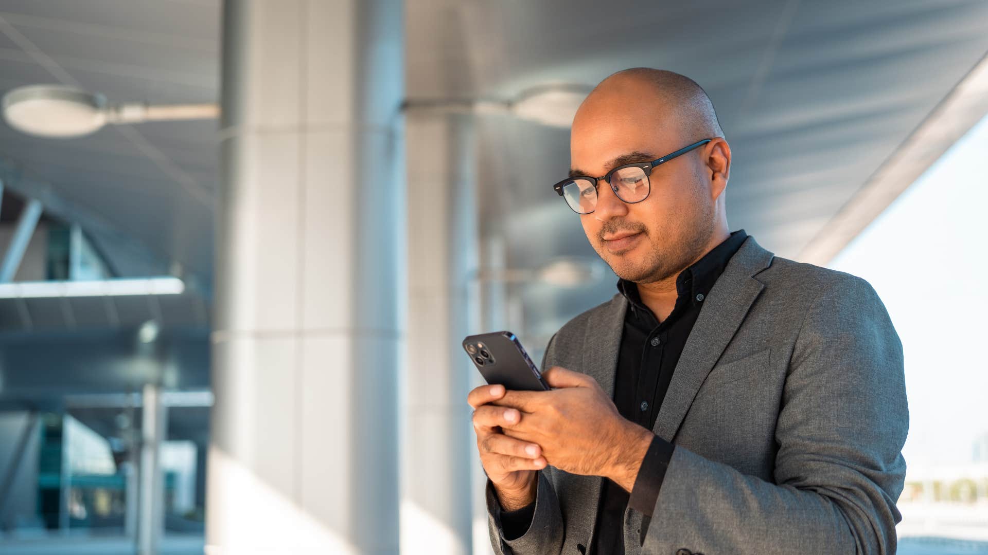 man standing outside looking at his phone
