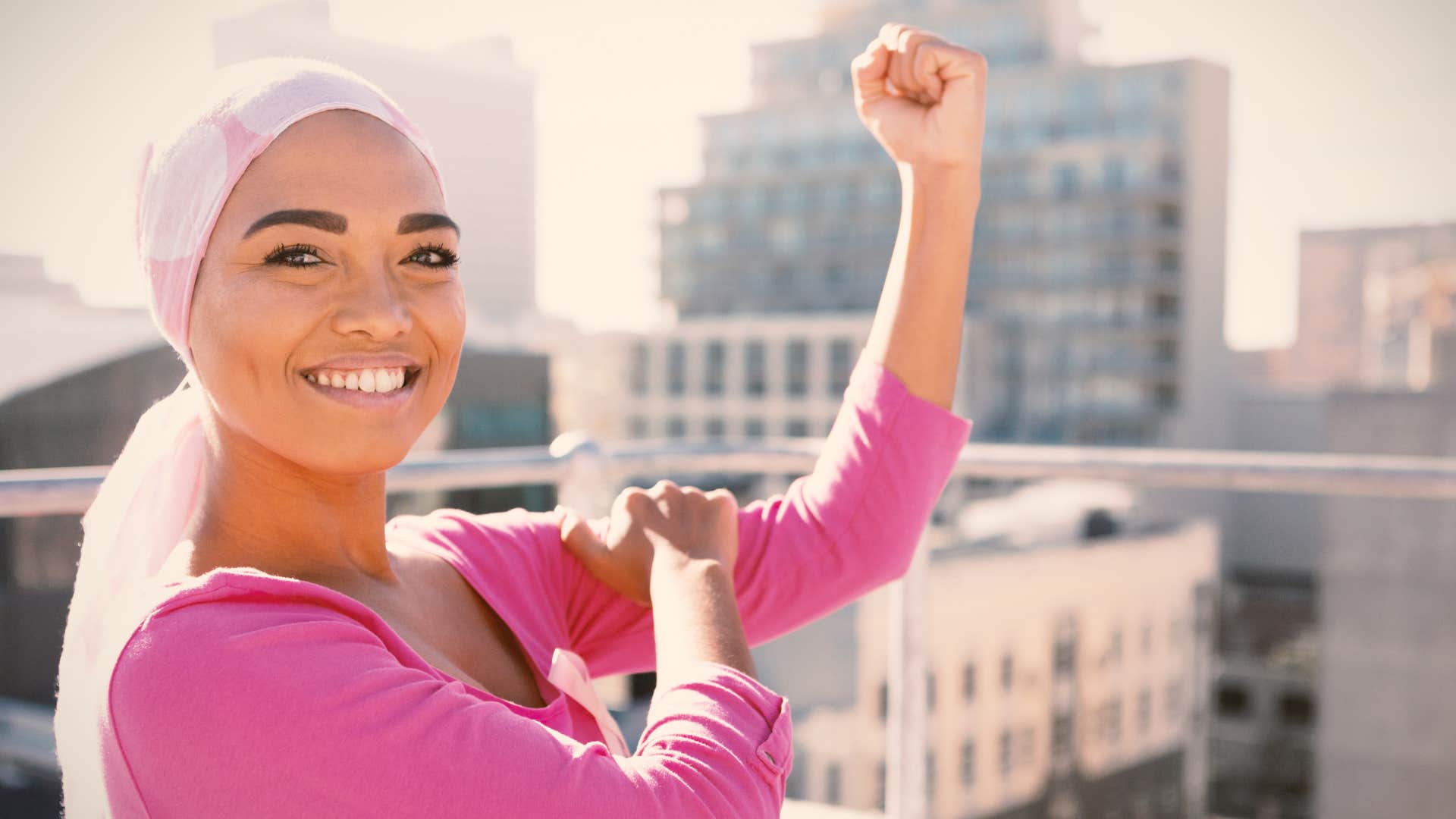 woman expressing her feminine energy smiling making a muscle