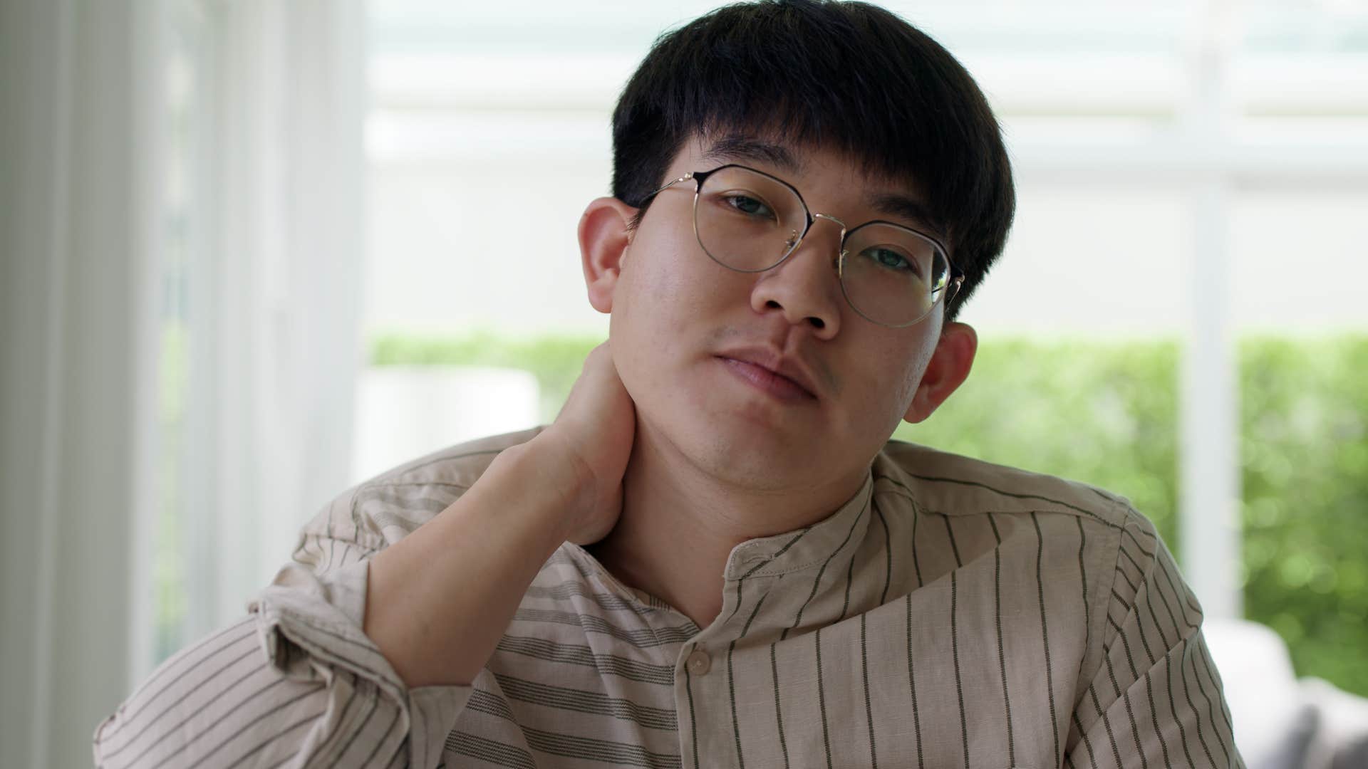 man stressed trying to avoid being called on at work or school