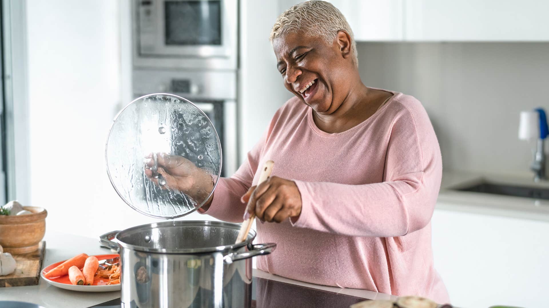 boomer woman cooking to send home leftovers with adult child