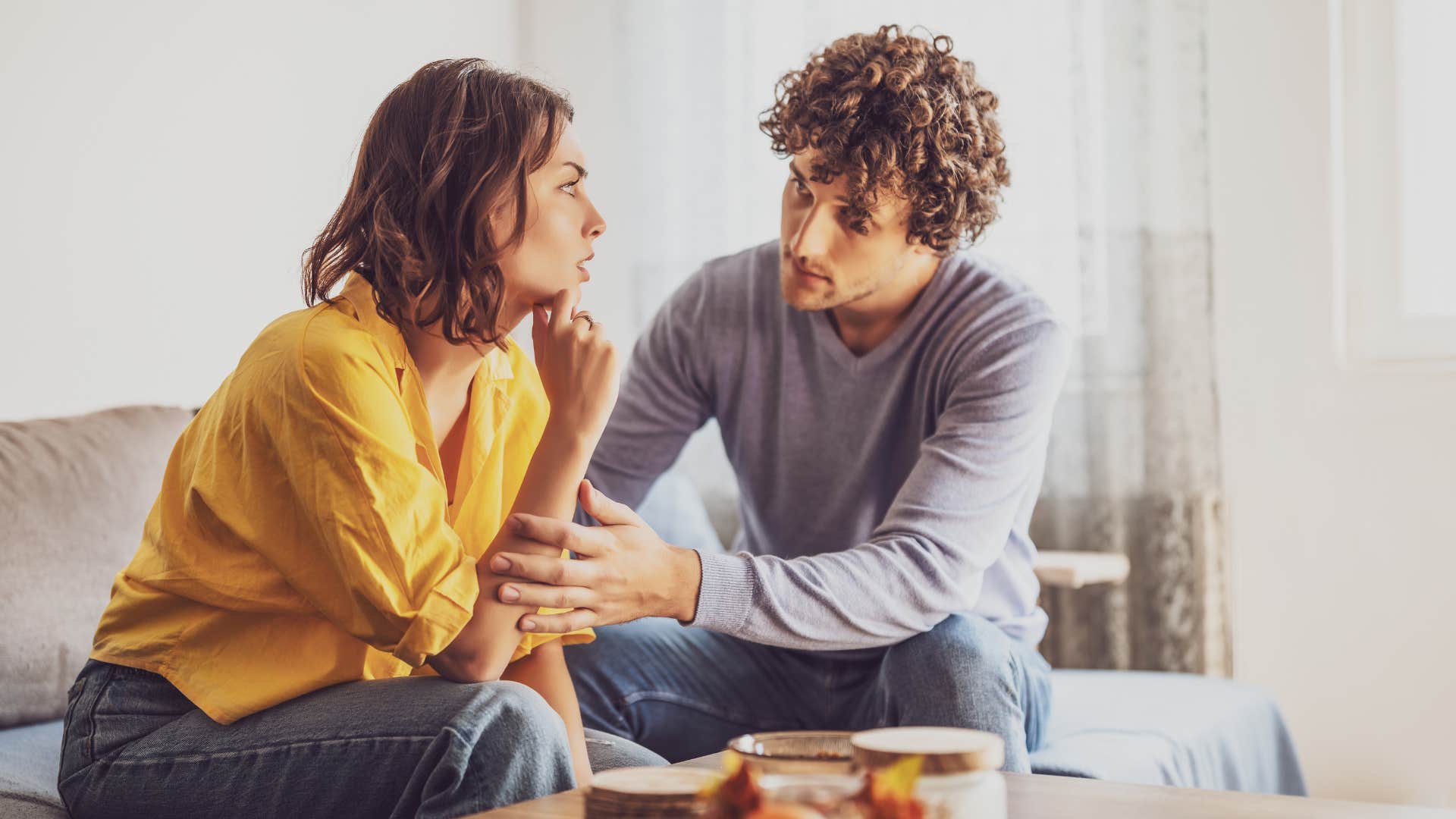 man in gray shirt comforting woman as woman thinks i wish he could actually listen to me