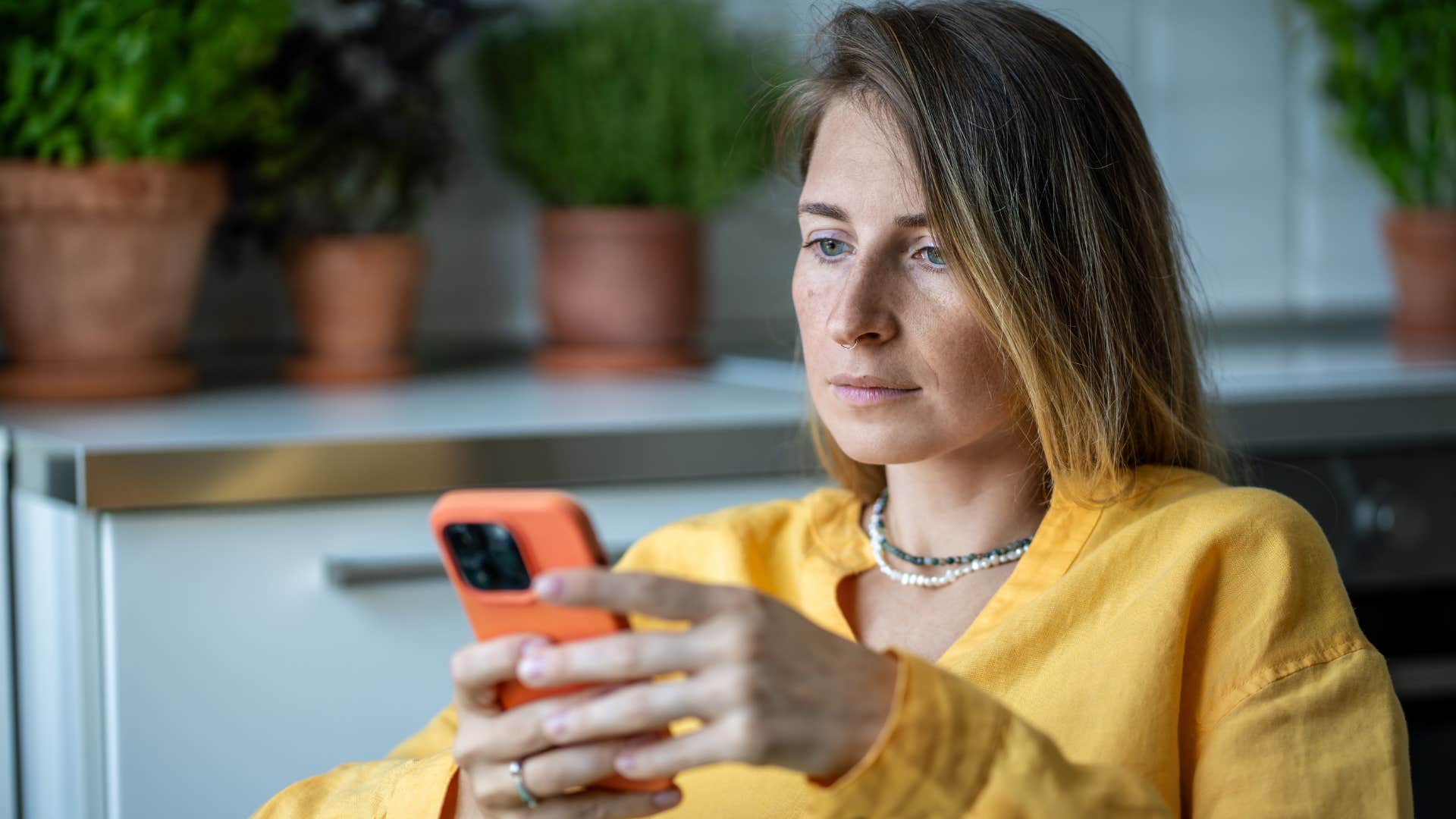 Woman who's afraid of something serious looking at her phone.