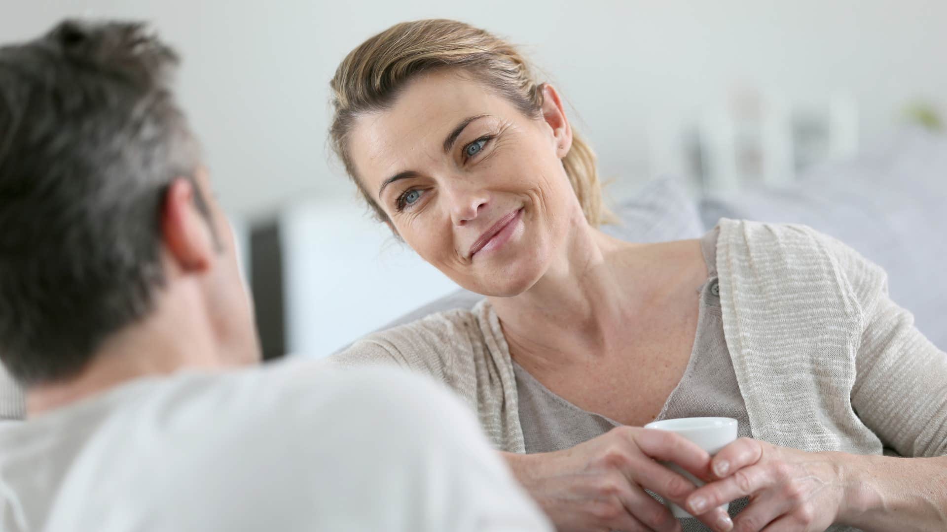 wife smiling at husband while he's telling story