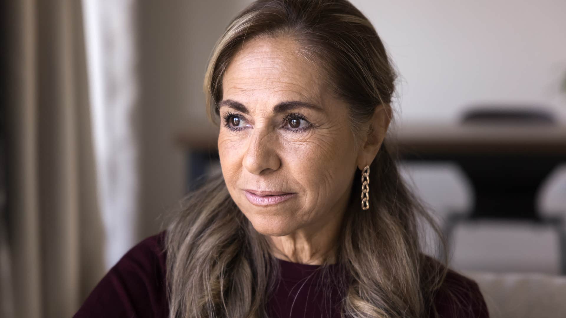 older woman who's rebuilding her life looking out a window