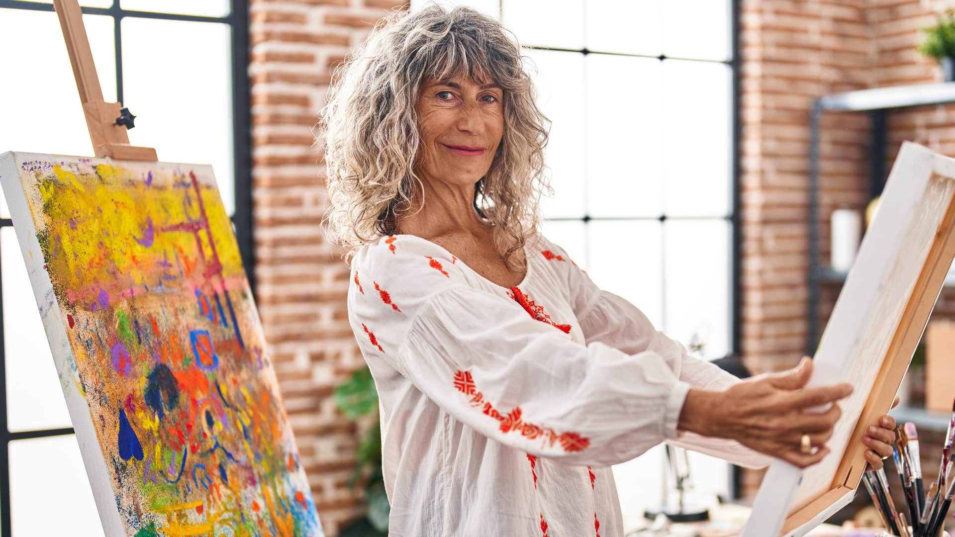 incredibly creative older woman painting at home
