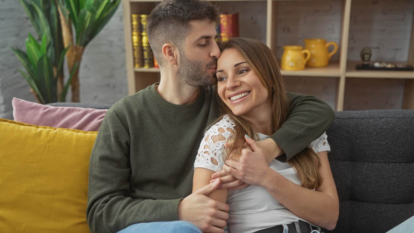 man deeply in love with woman kissing her head gently