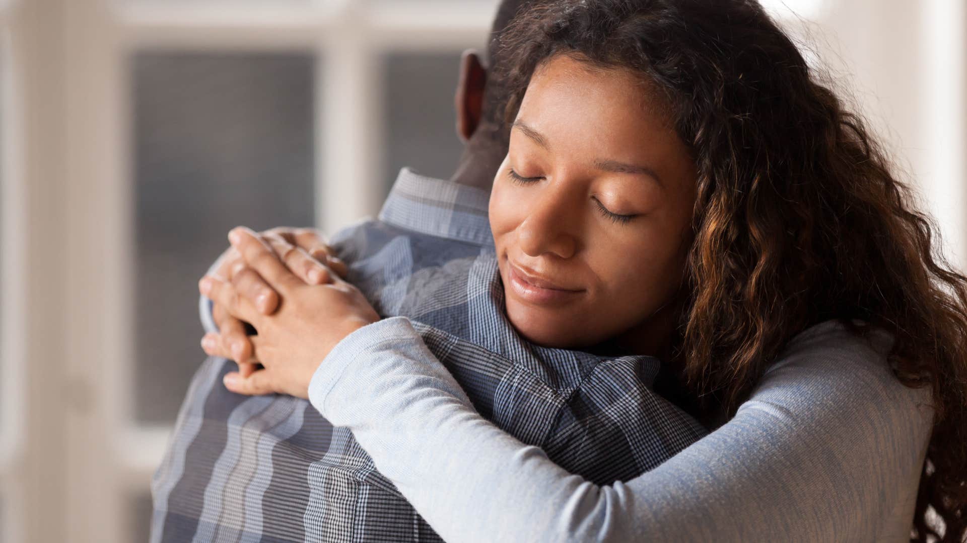 Forgiving person apologizes with a hug