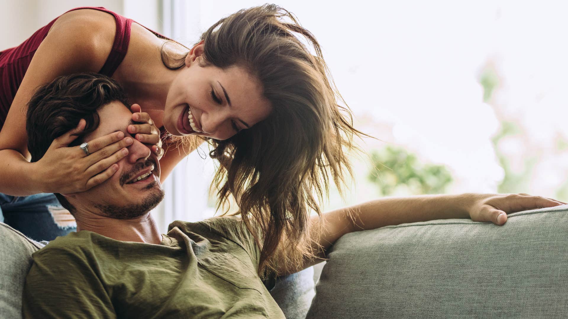 woman being flirty with man covering his eyes