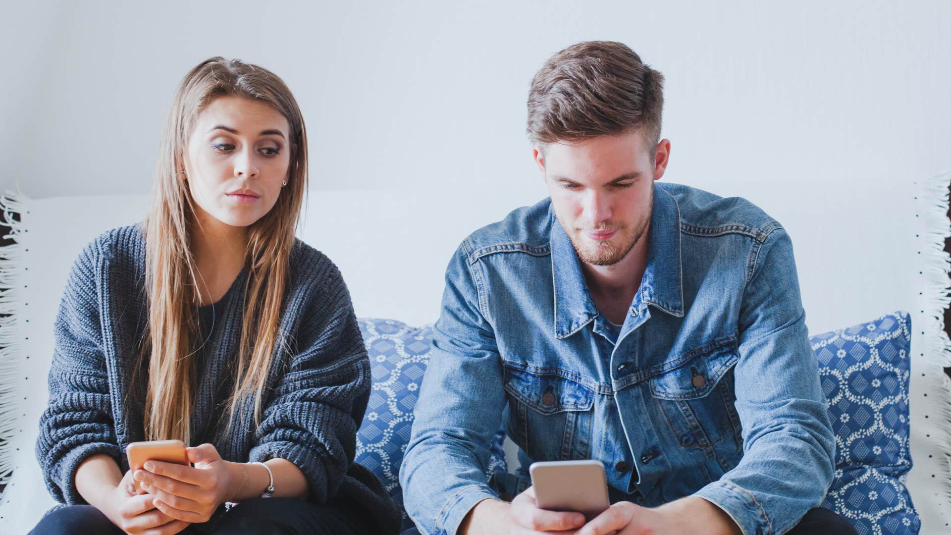 jealous woman looking at her partner and his phone