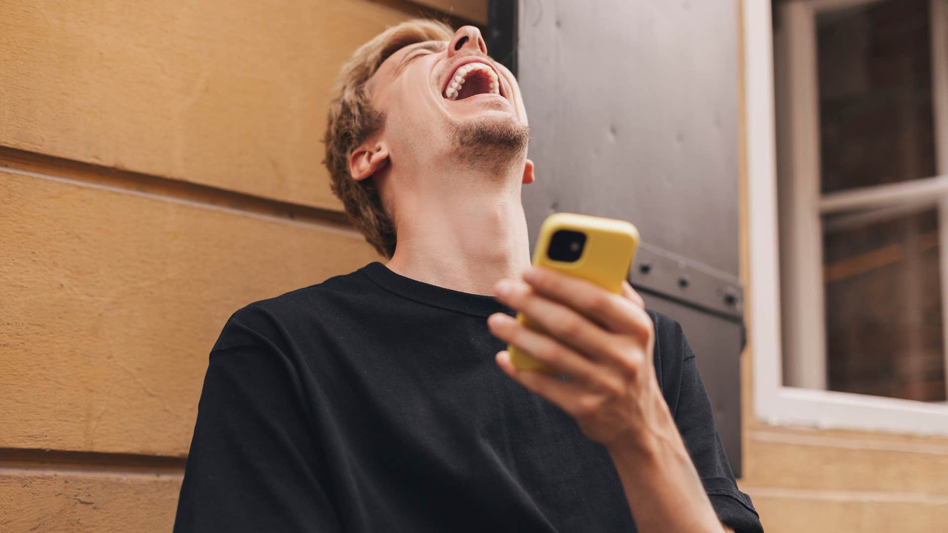 man who is irresponsible laughing at his phone