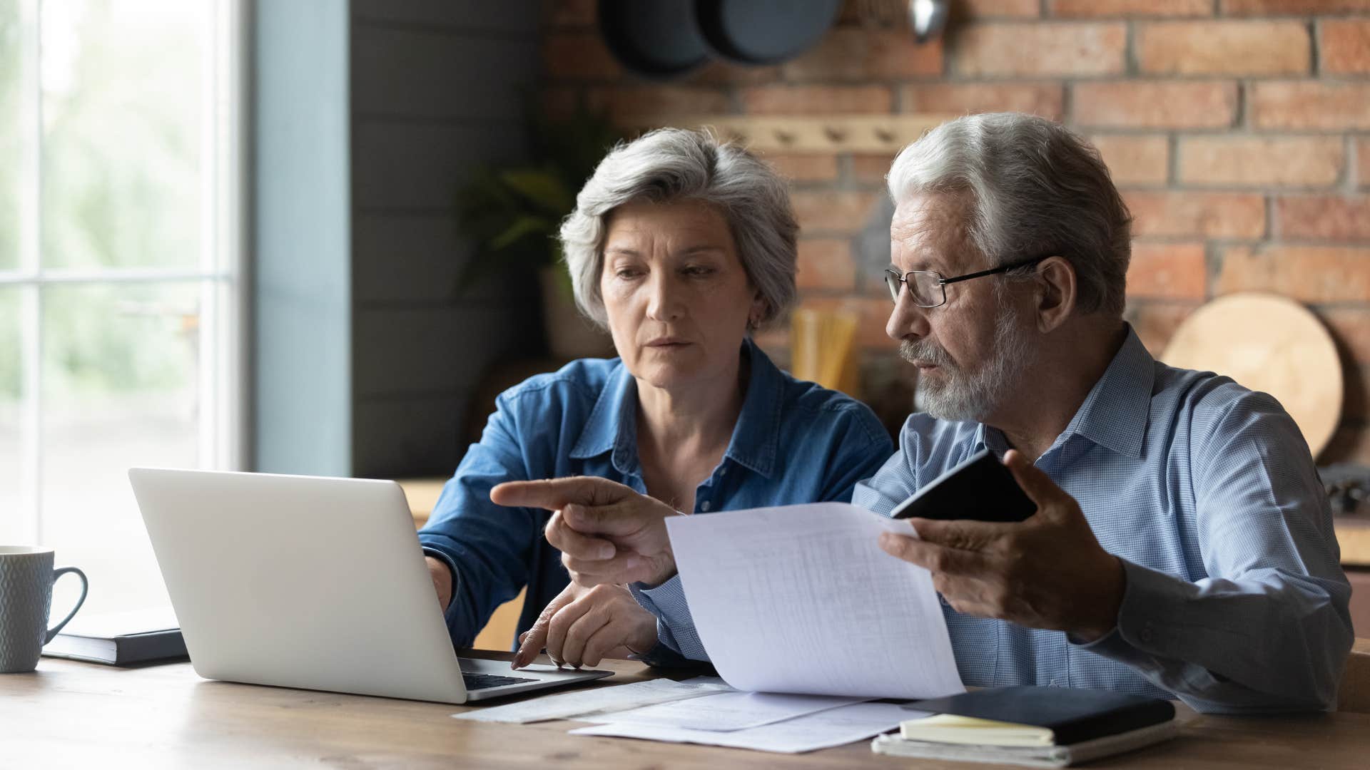 older couple saving for a rainy day checking their bills