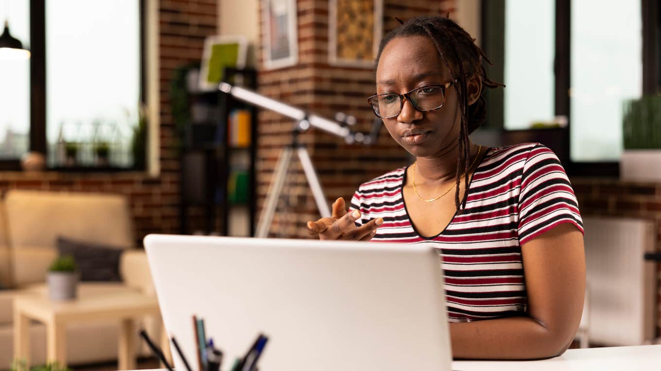Boss Demands Employees Working From Home Check In Every 5 Minutes During Their Workday focused black woman speaking with team during virtual meeting on laptop