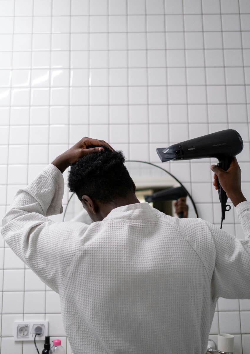 man blow drying his hair