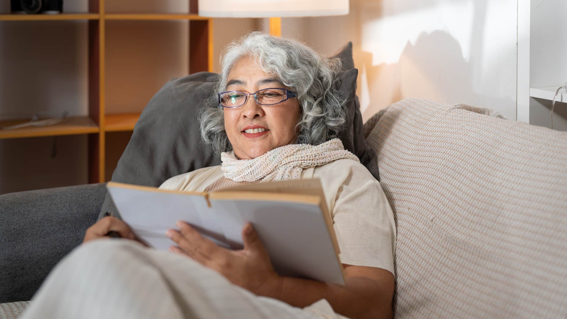 woman relaxing and reading on couch to ease anxiety