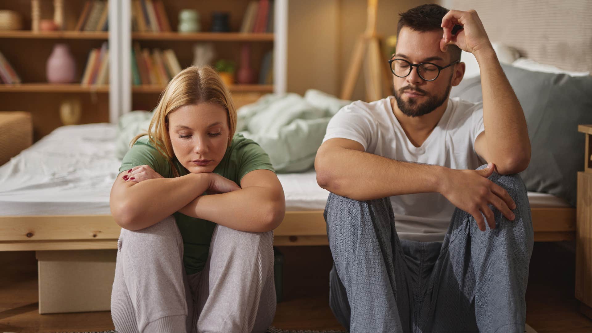 if a couple barely touches each other anymore, it usually means these things about their marriage they aren't meeting one another's love language couple sitting on the floor looking upset as they aren't meeting one another's love language