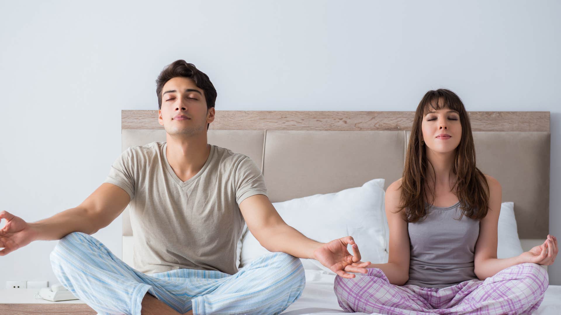 couple meditating in bed creating everyday rituals that ground them
