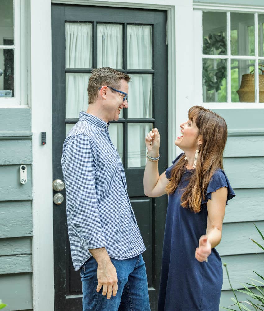 A couple in front of their first house that the dad-to-be doesn't like because he misses his apartment