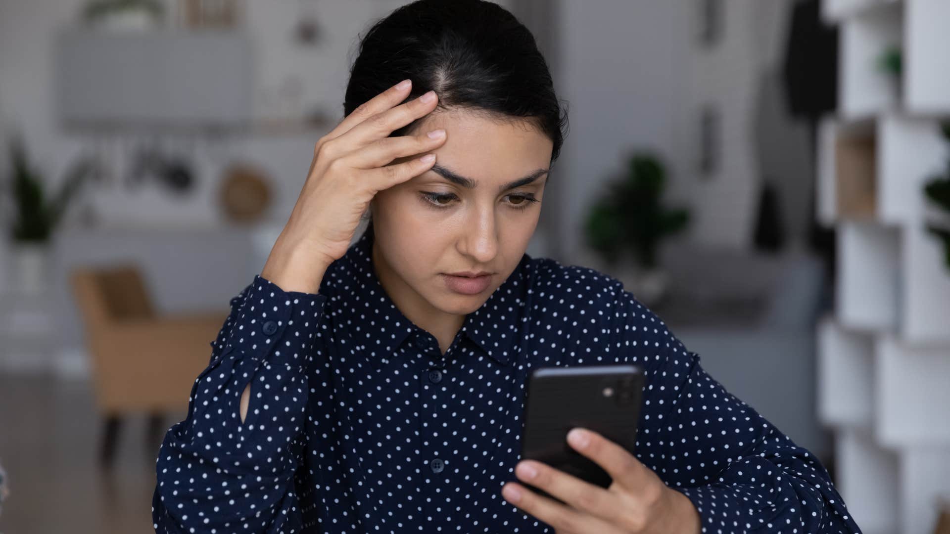 annoyed woman texting on her phone at home