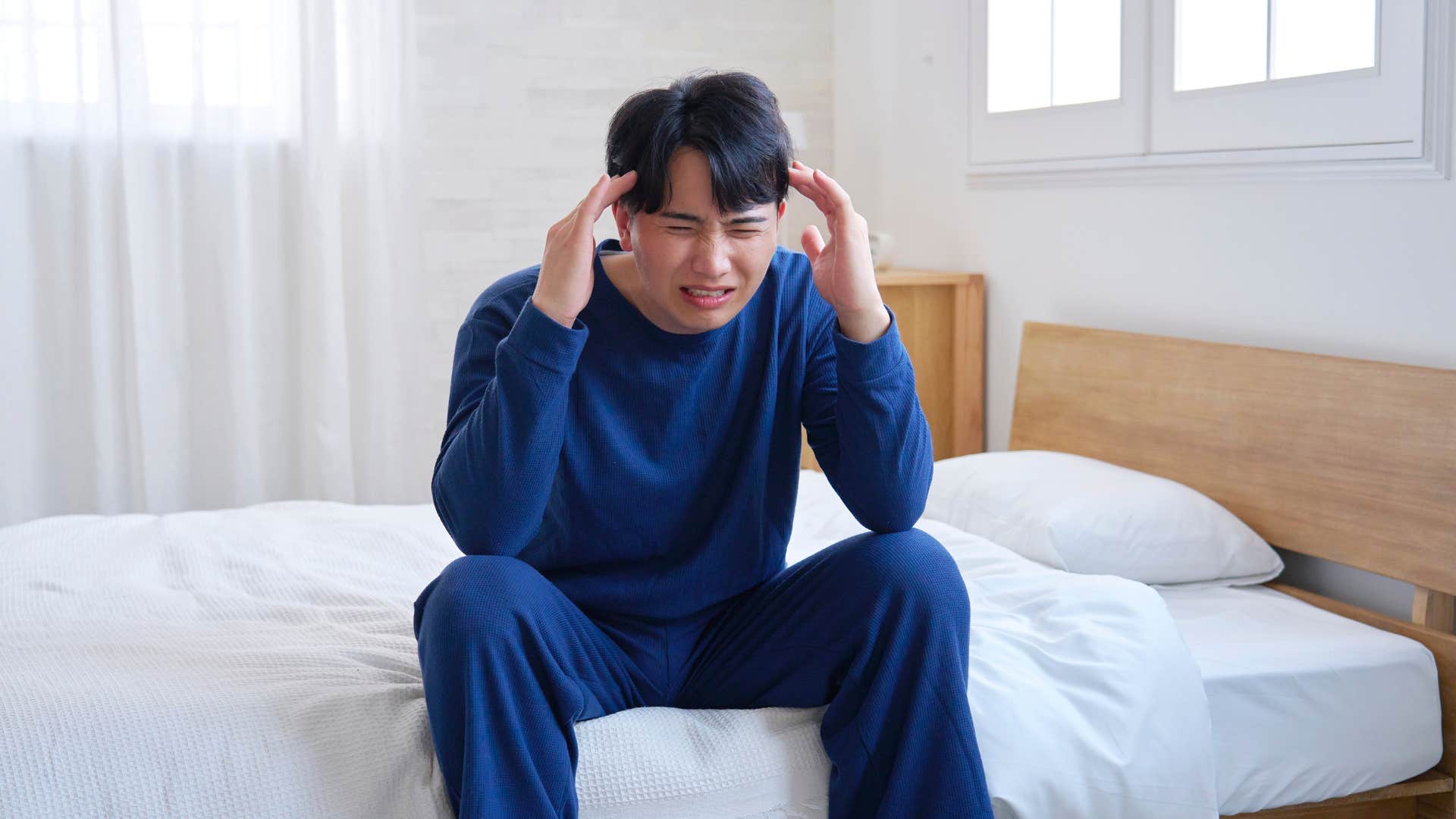 man who has a migraine with the symptom of light sensitivity