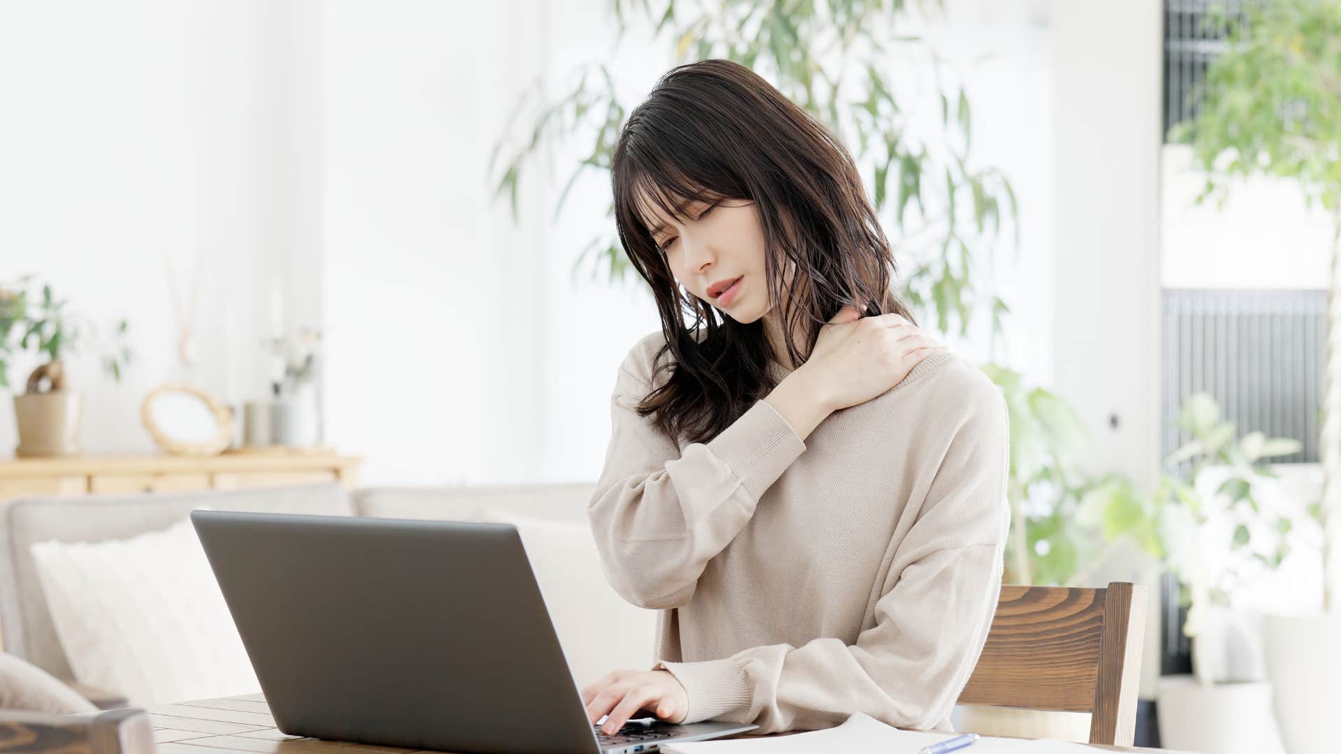 woman who has a migraine with the symptoms of stiffness