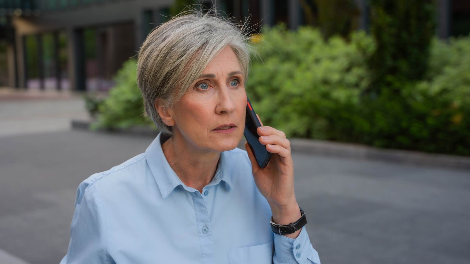 older woman looking insulted talking to friend on the phone