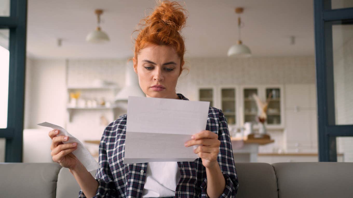 Finance Expert Doesn't Know How Single People Are Getting By In This Economy single woman worried about money looking at bill and receipt
