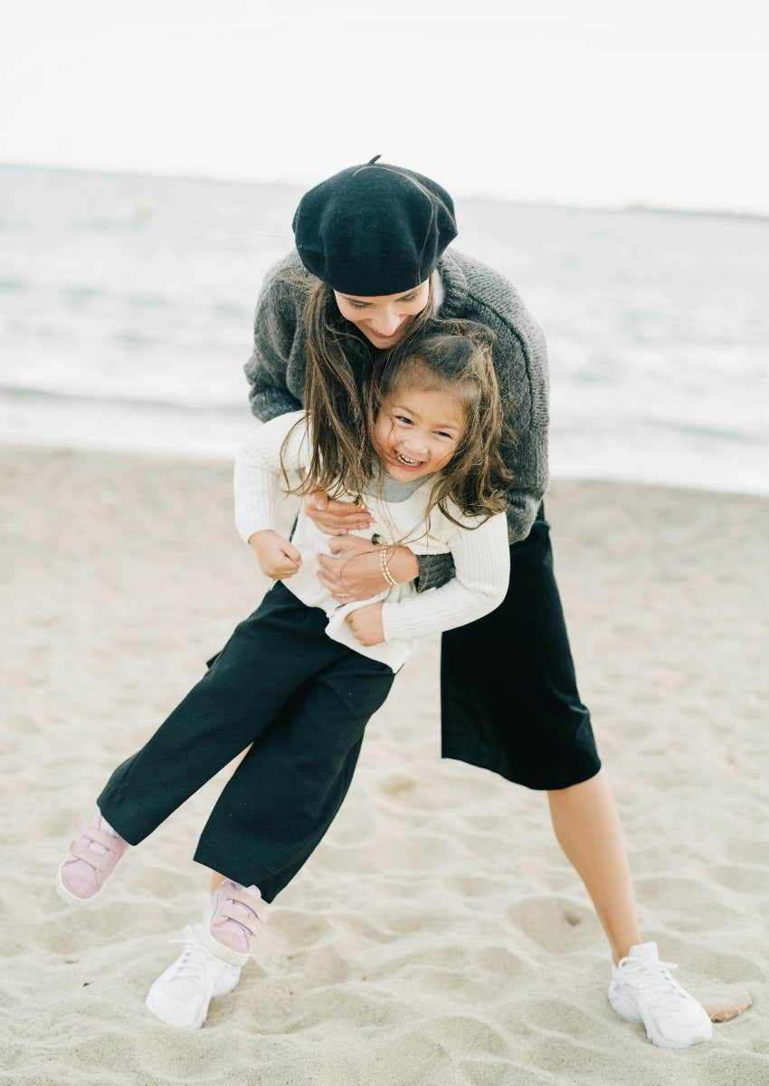 Gen Z Parents Have Abandoned Gentle Parenting And Are Doing This Instead gen z mom and daughter at beach