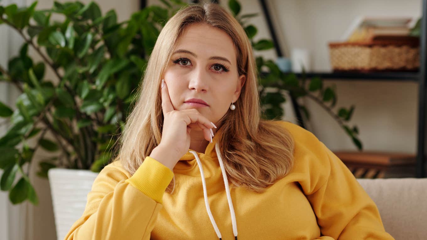 serious woman sitting alone on her couch