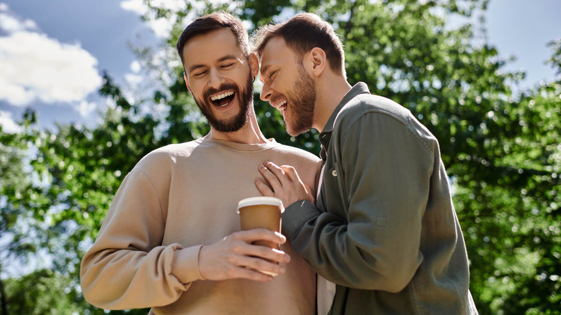 couple drinking coffee smiling laughing together outside