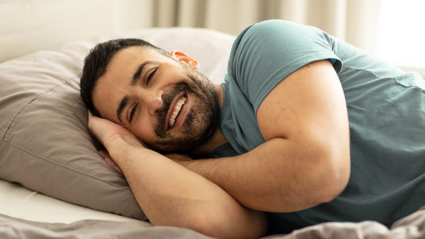 If A Husband Starts Sleeping Better Alone, He Usually Has These Reasons happy smiling man laying in bed after sleeping alone
