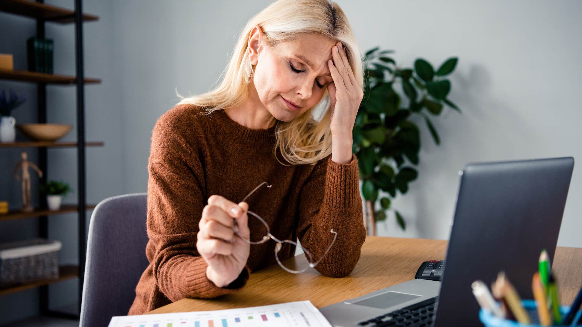 woman feeling overwhelmed working at laptop