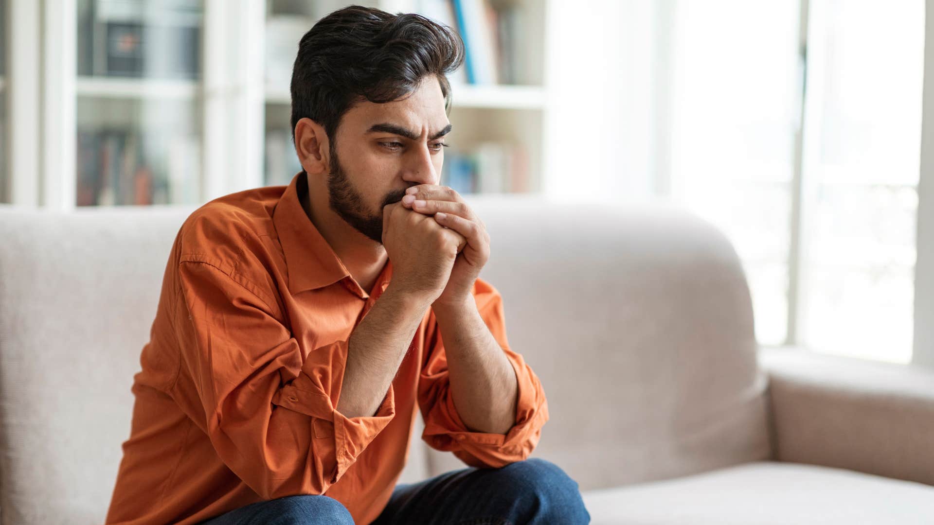 man who's not boosting his partner's mood sitting on the couch
