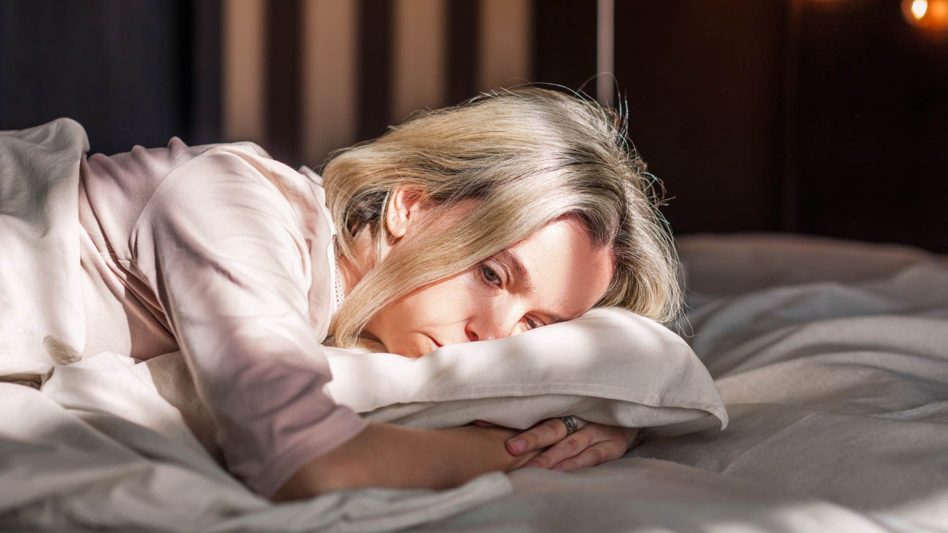 woman alone in bed not cuddling husband