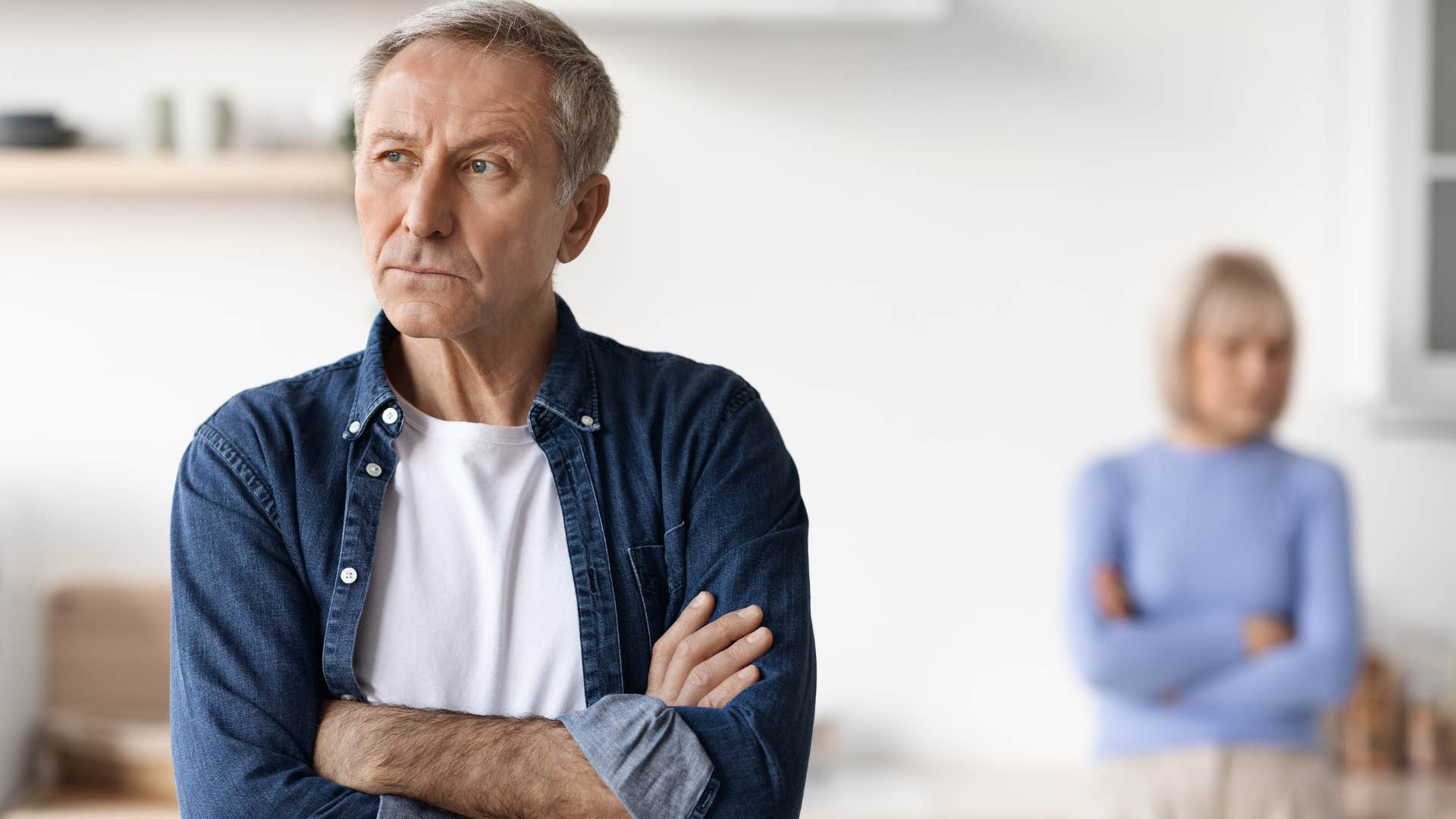 upset man saying you don't even care turned away from his wife