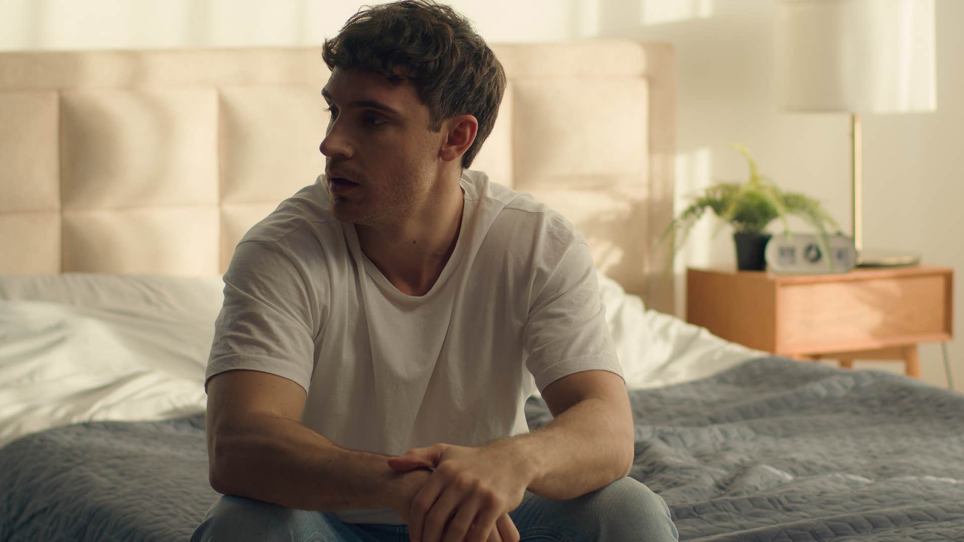 man who needs space to think sitting on his bed