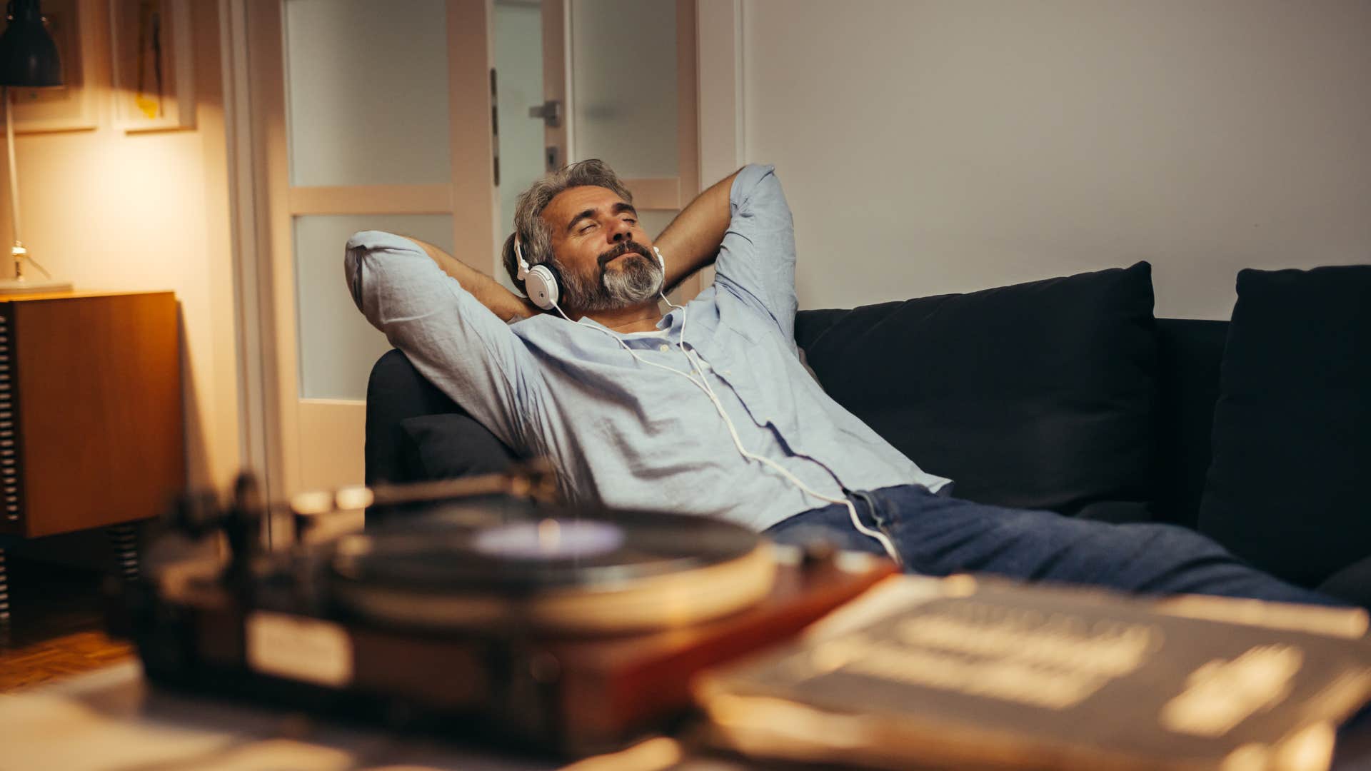 man listening to music and relaxing on couch