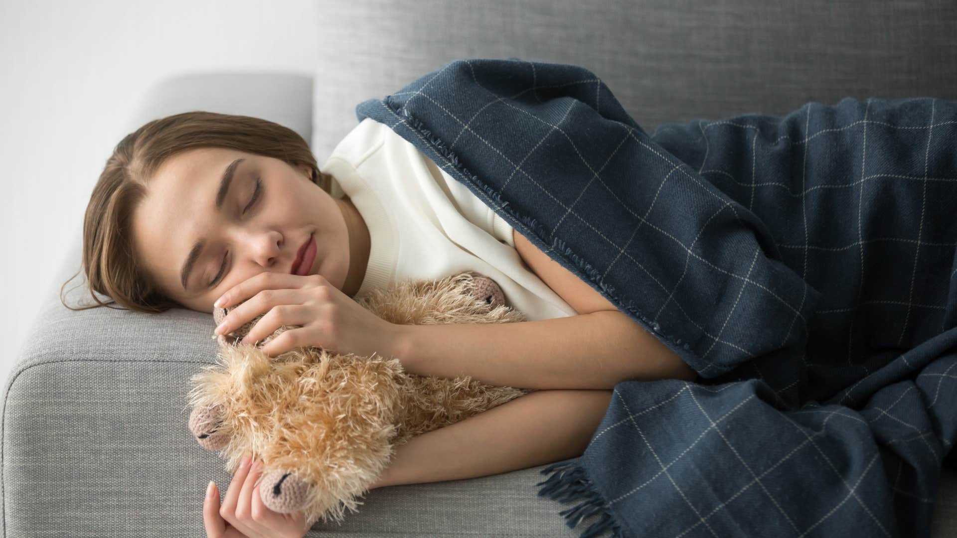 woman sleeping with stuffed animal for comfort