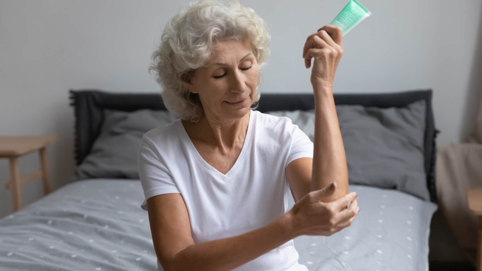 Woman who hoards freebies putting on lotion.