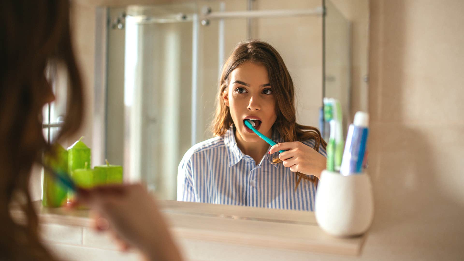 Woman who uses everything fully brushing her teeth.