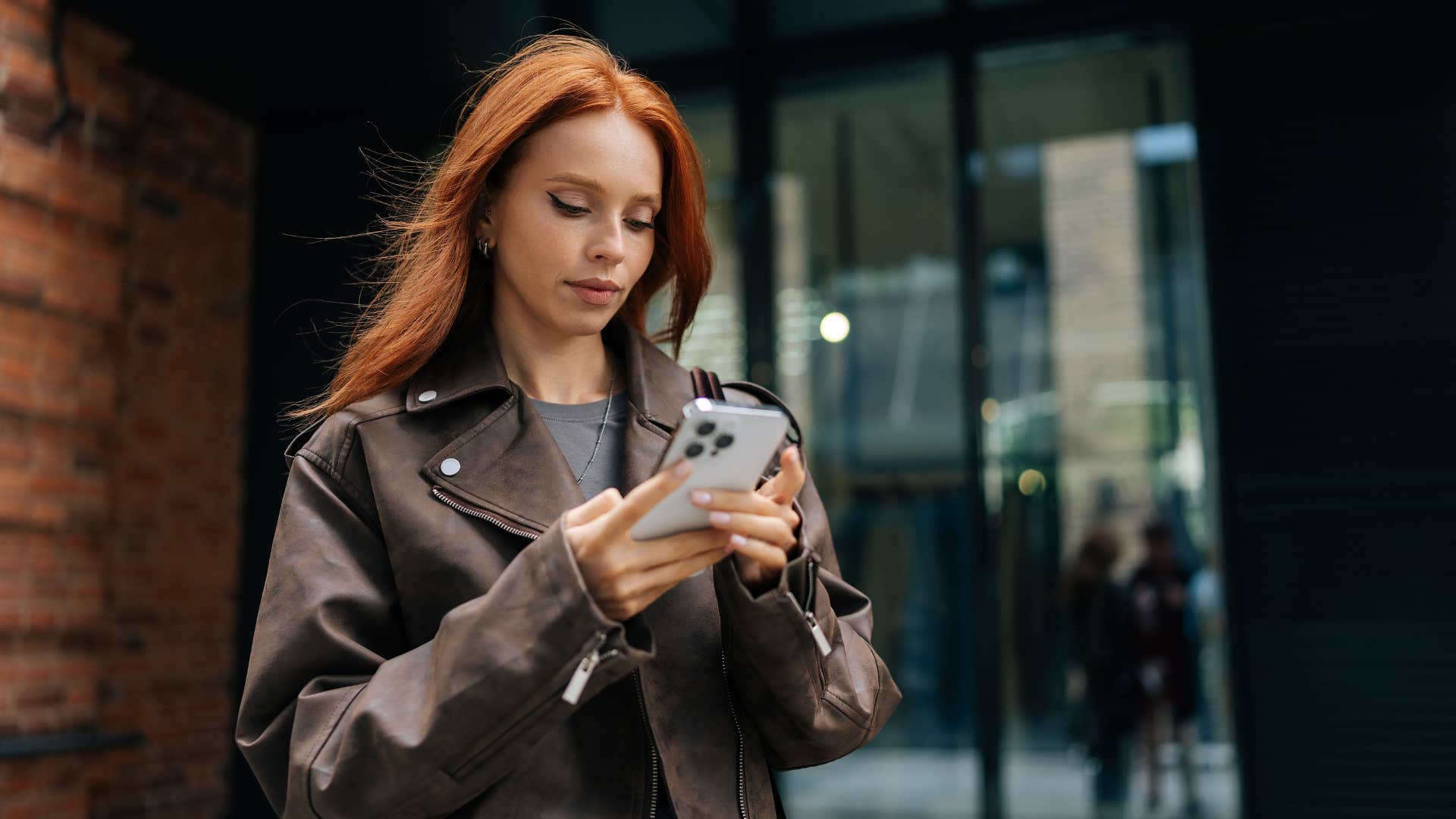 woman looking at phone thinking people are jealous of her