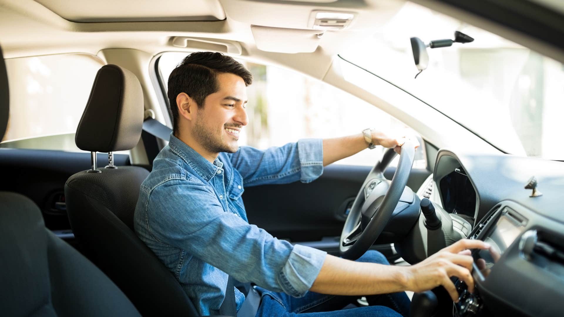 man listening to radio in car