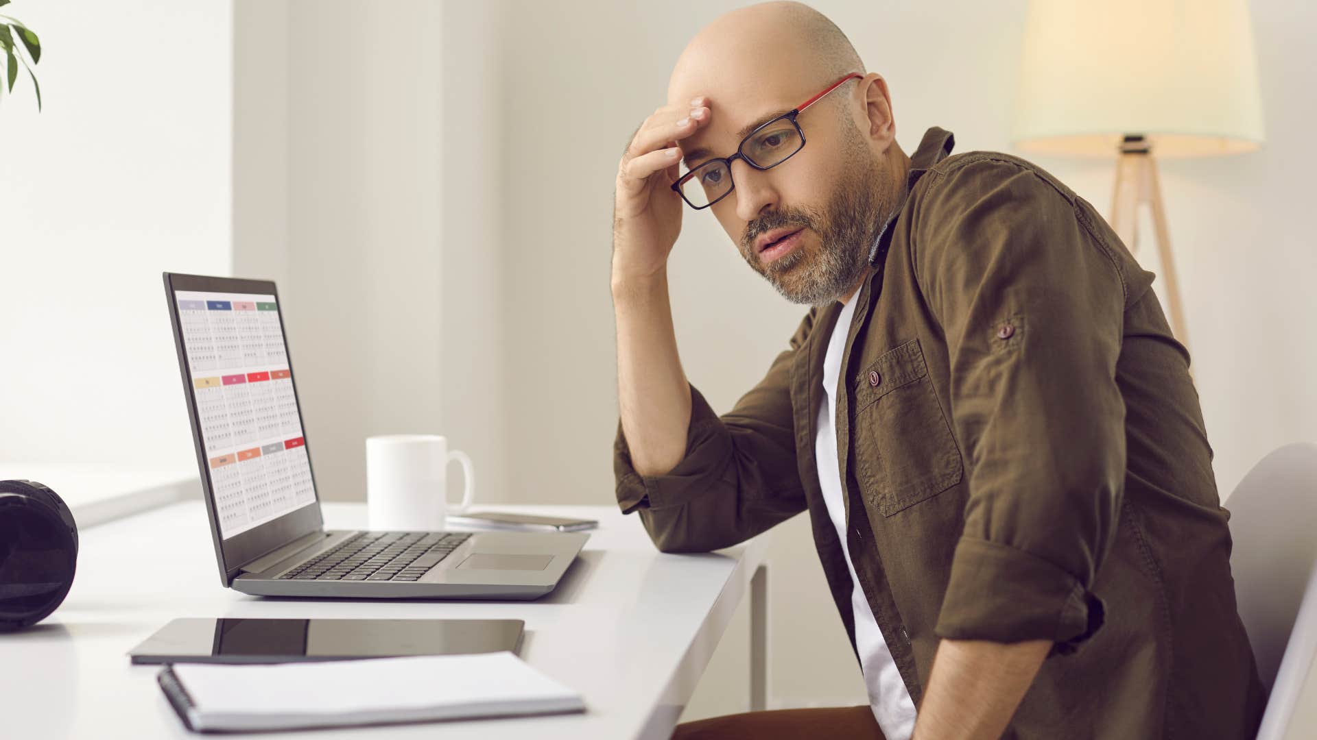 Man who uses a full calendar looking stressed at home.